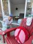 Preview: Roter Adirondack Chair USA Classic Relax auf einer sonnigen Terrasse.