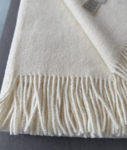 Preview: Gefaltete cremeweisse Kuscheldecke Gant mit dekorativem Fransenabschluss
